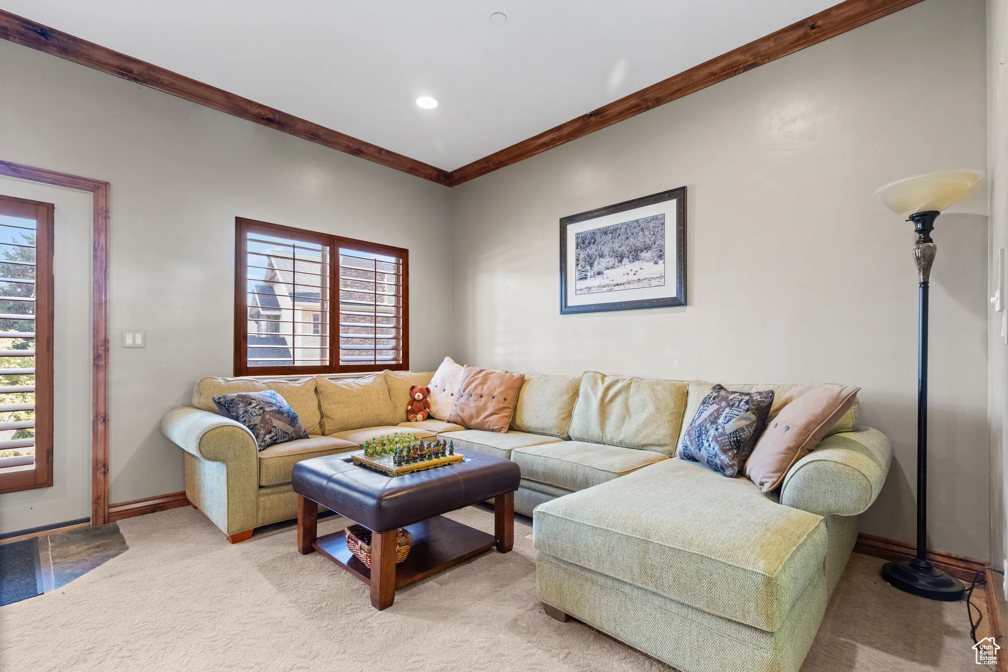 Living room featuring crown molding and light colored carpet