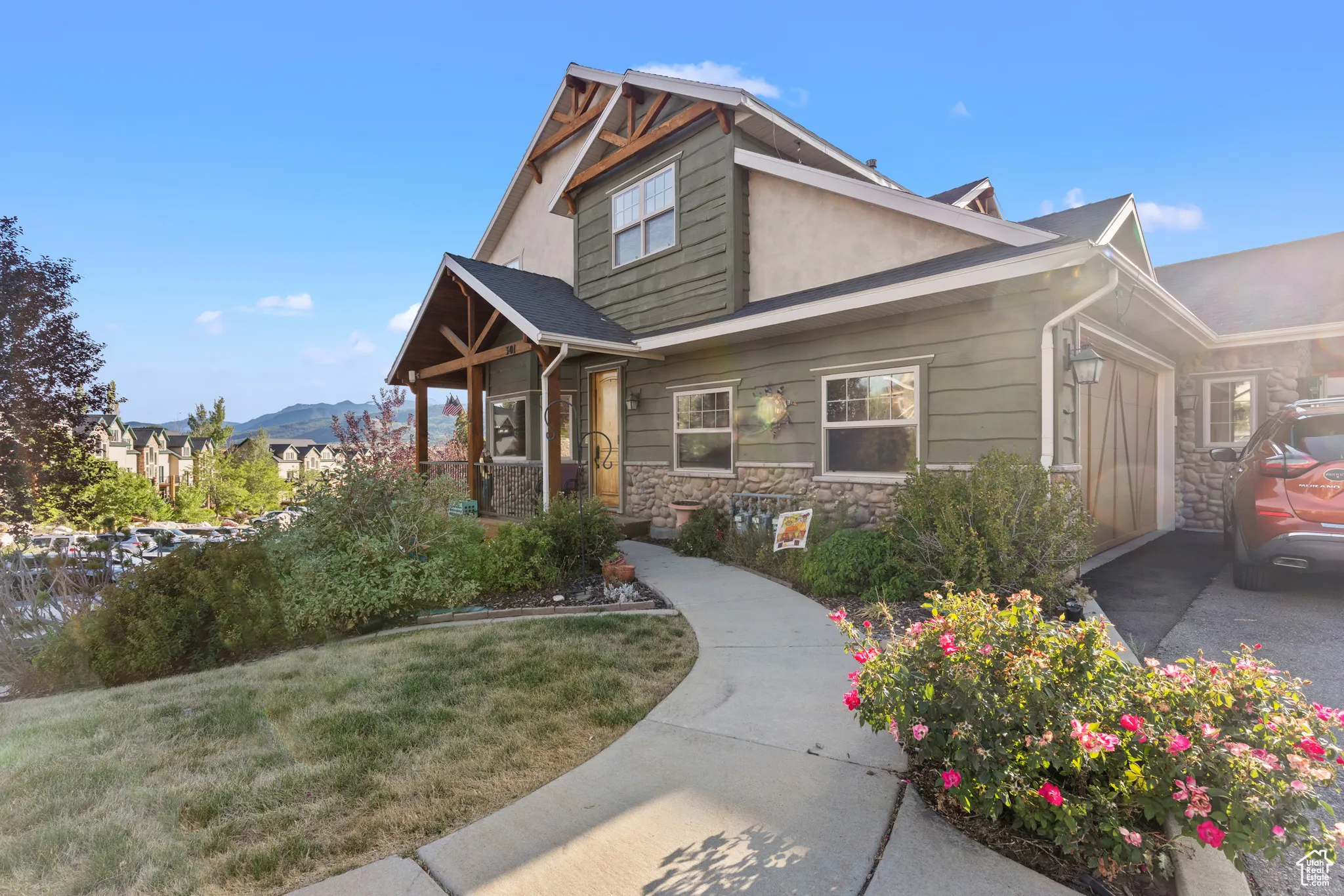 Craftsman-style home featuring stone siding and a front lawn