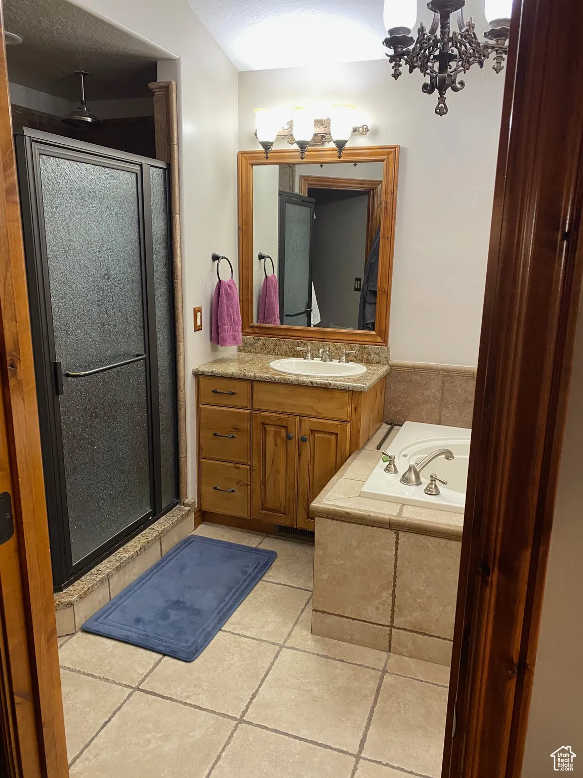 Bathroom with a stall shower, tile patterned floors, vanity, a garden tub, and a textured ceiling
