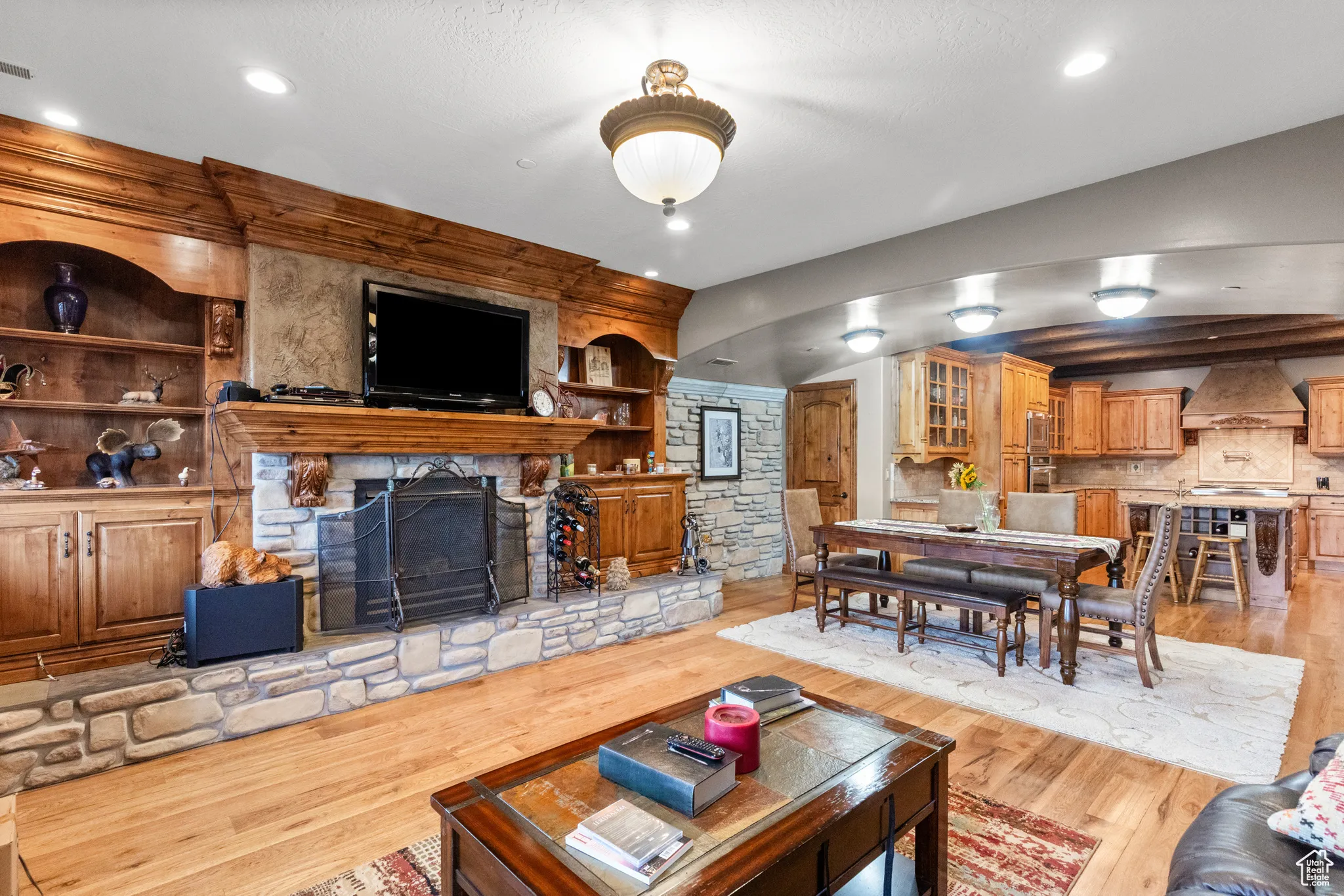Living room with a fireplace, light wood-style floors, recessed lighting, and built in shelves