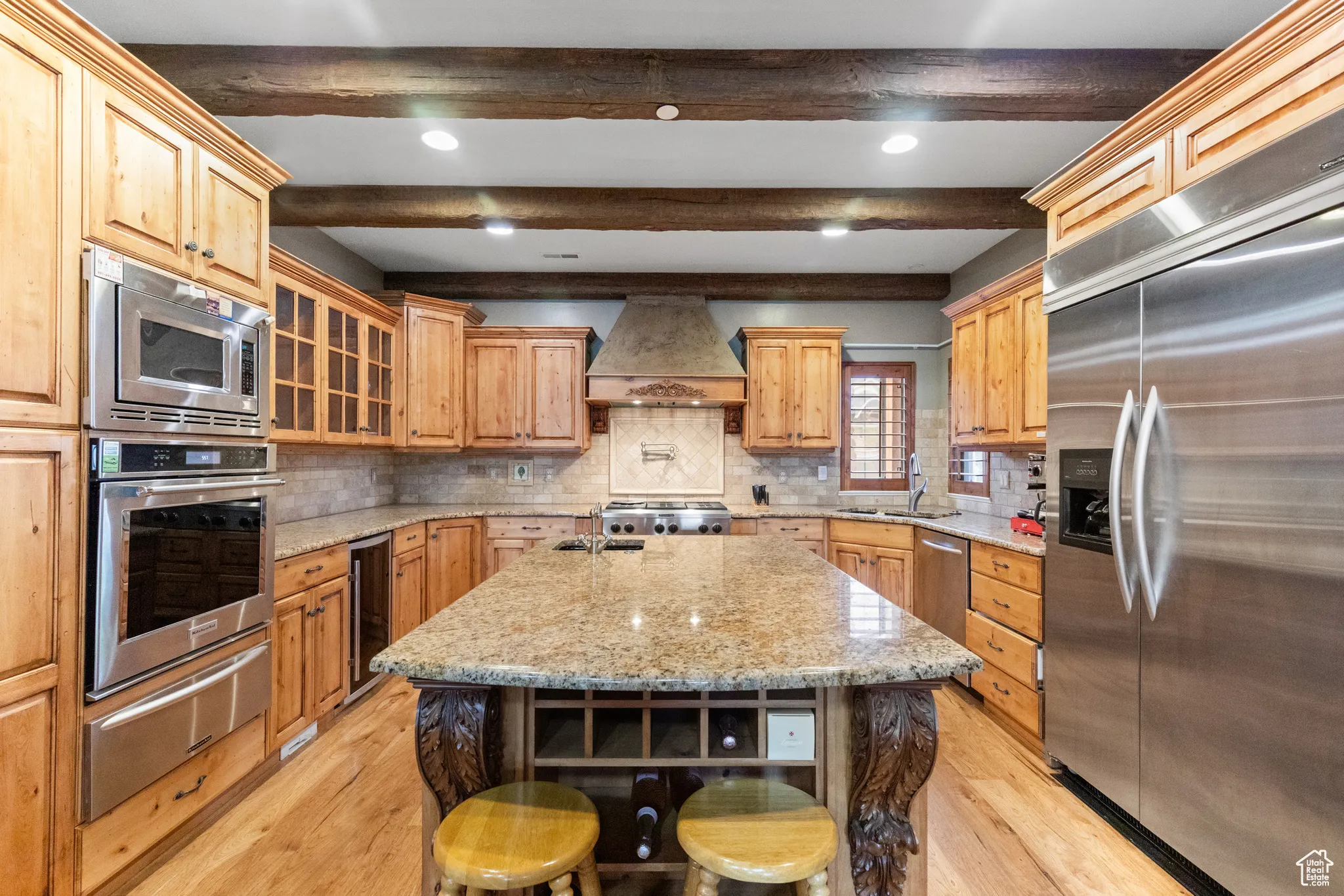 Kitchen with built in appliances, light wood-type flooring, tasteful backsplash, beamed ceiling, and a warming drawer