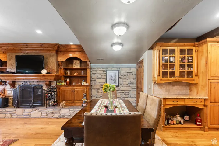 Dining space featuring wood finished floors, a fireplace, and recessed lighting
