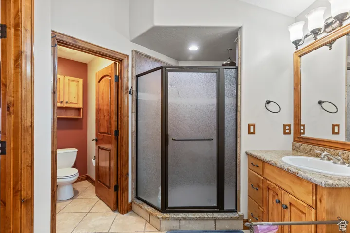 Bathroom featuring tile patterned flooring, vanity, and a shower stall