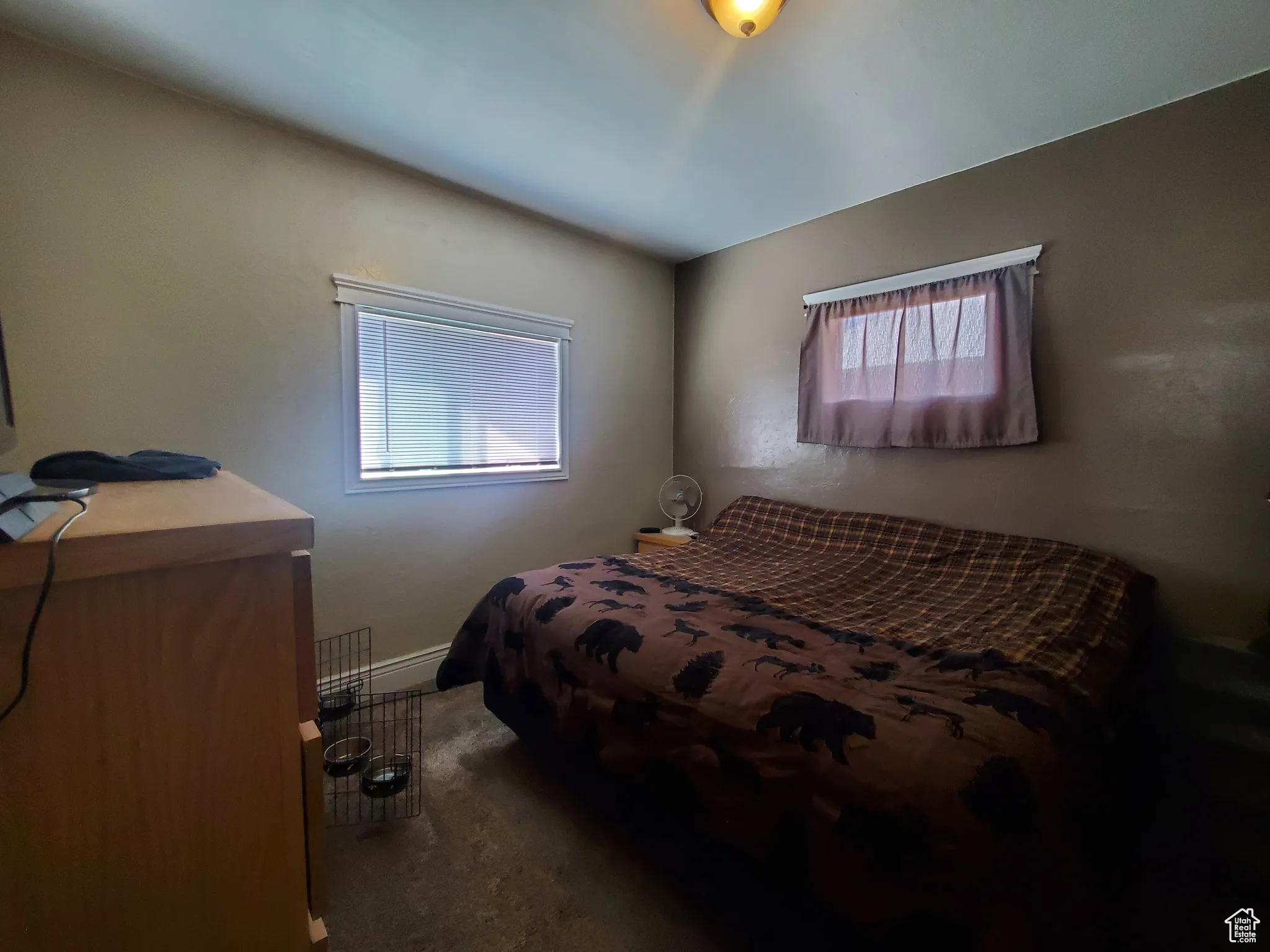 Bedroom with dark colored carpet and baseboards