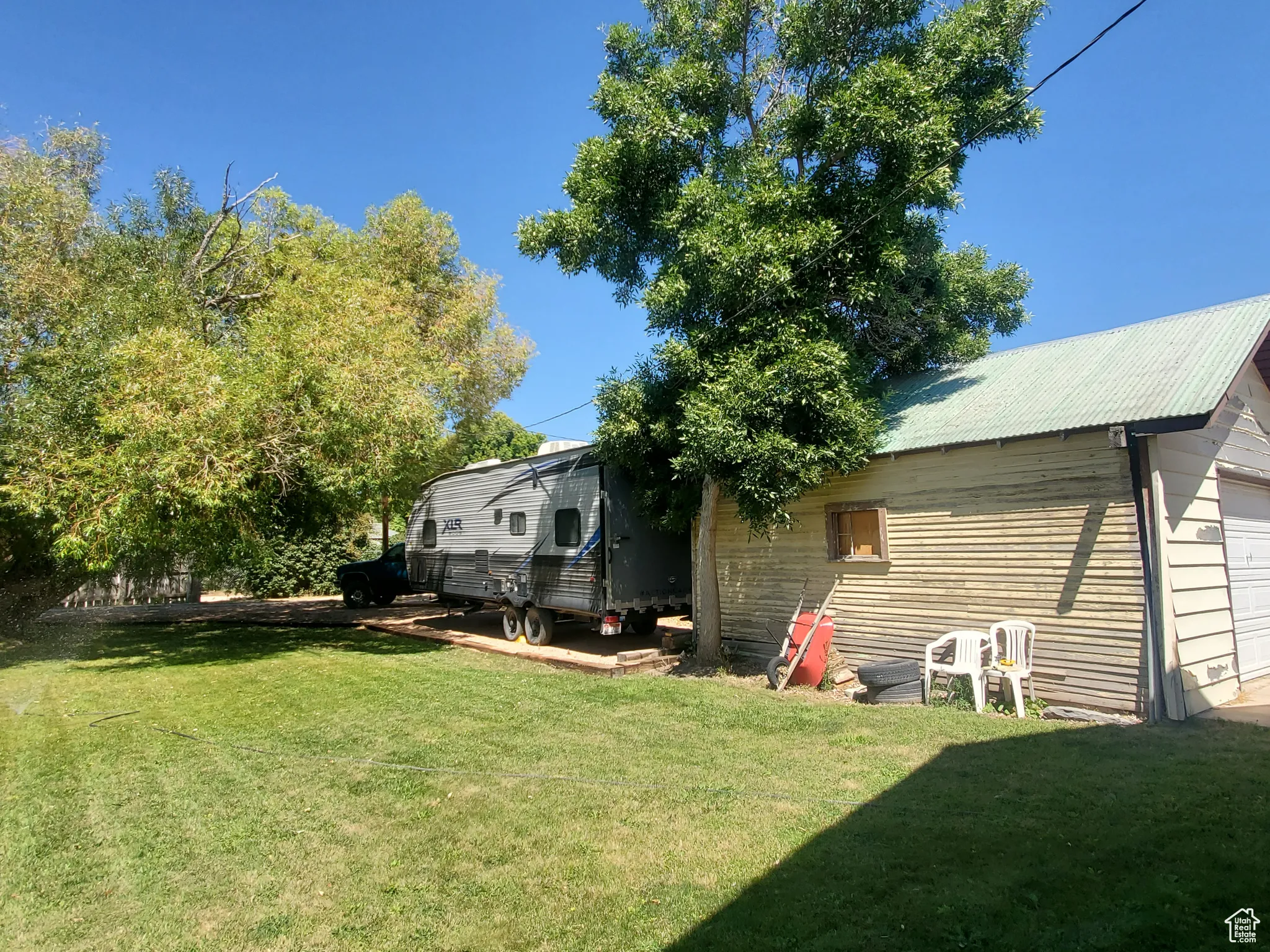 View of green lawn featuring a garage and RV Parking.