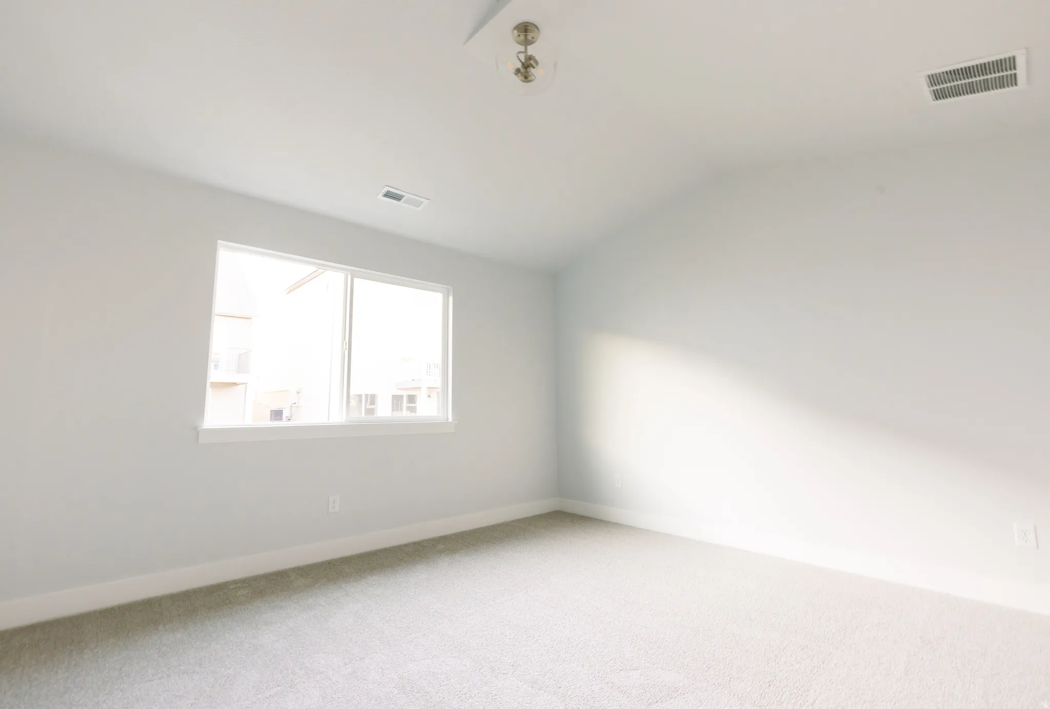 Empty room with lofted ceiling and carpet floors