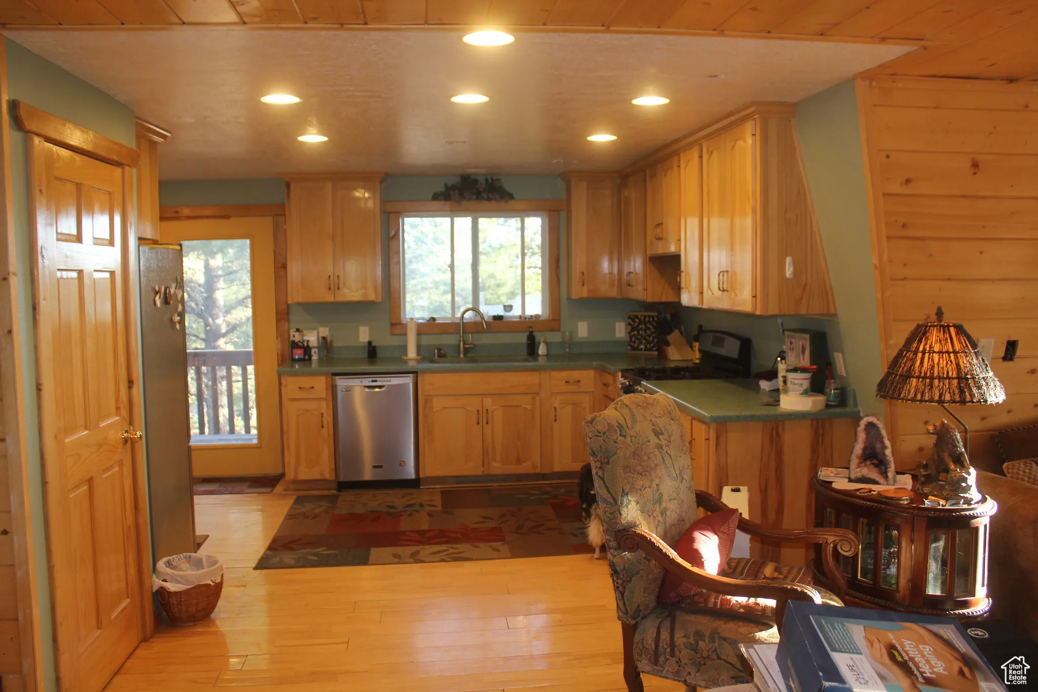 Kitchen featuring dark countertops, wooden ceiling, light wood-style flooring, appliances with stainless steel finishes, and recessed lighting