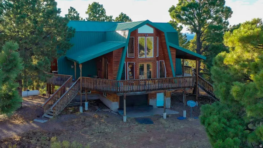 Rear view of house featuring a deck and a metal roof