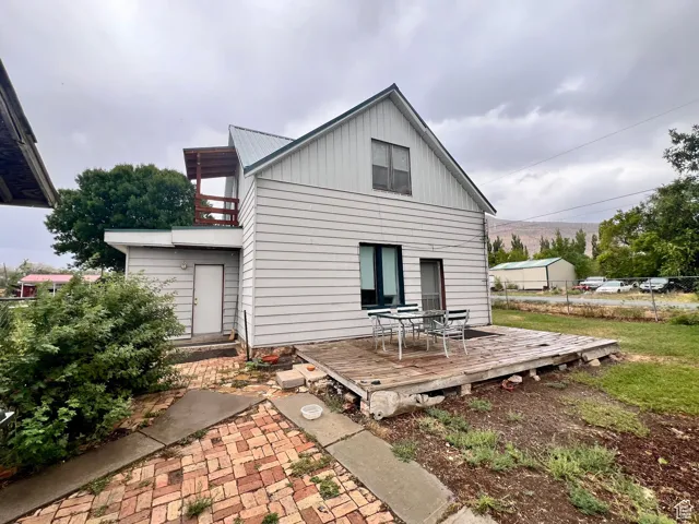 Back of property featuring a balcony, board and batten siding, and a wooden deck