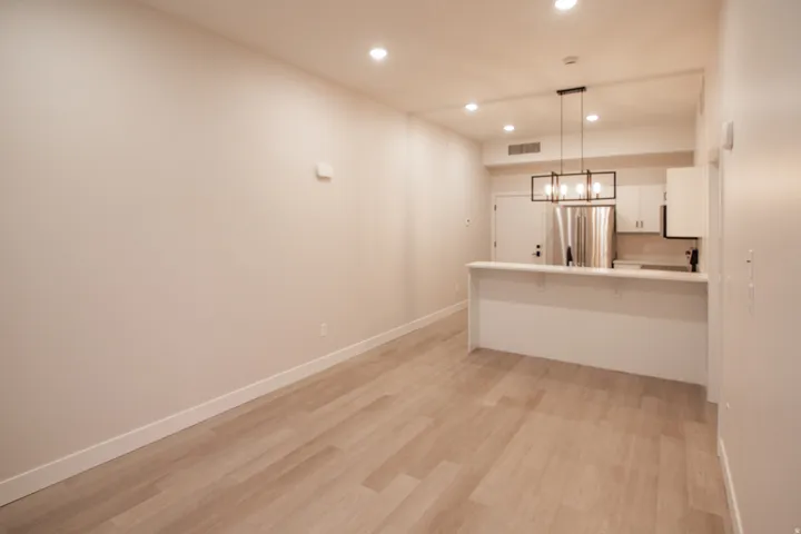 Kitchen with recessed lighting, a kitchen breakfast bar, white cabinetry, light countertops, and hanging light fixtures