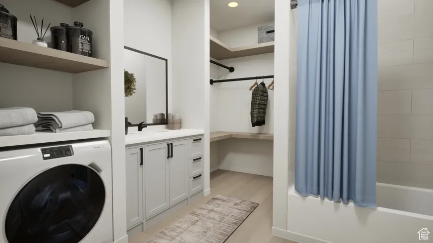 Washroom featuring washer / dryer and light wood-style flooring