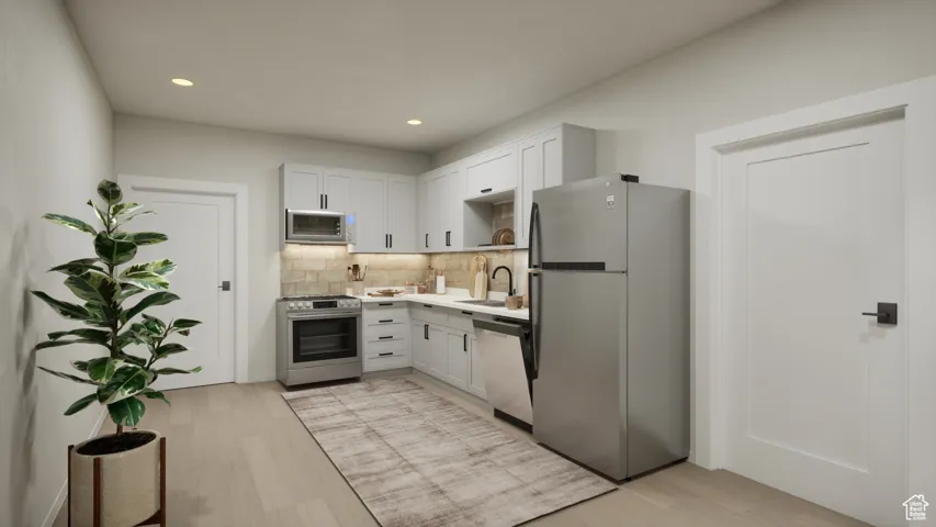 Kitchen with appliances with stainless steel finishes, light wood-style flooring, recessed lighting, decorative backsplash, and light countertops