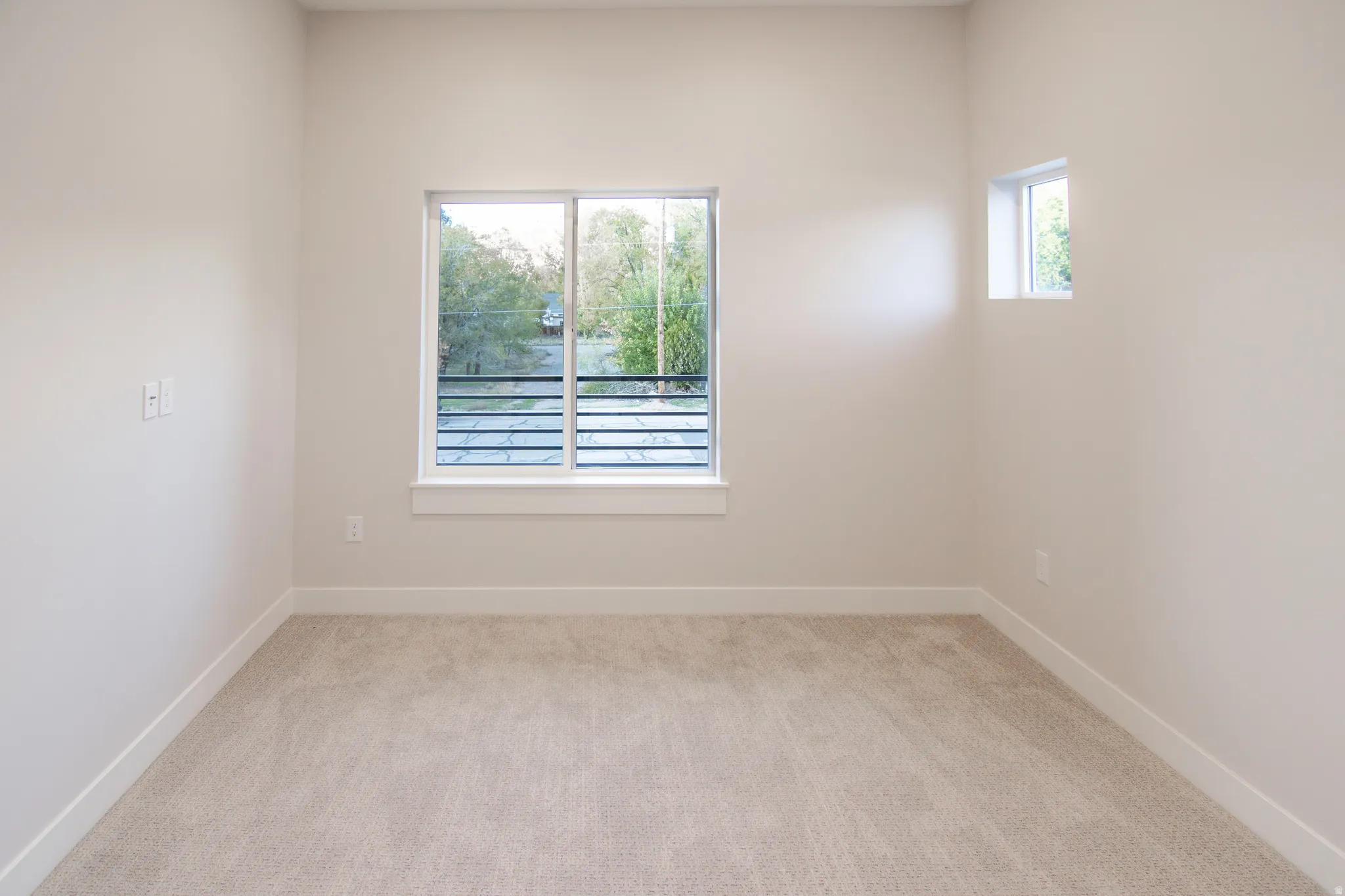 Unfurnished room with light colored carpet and baseboards