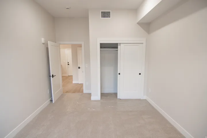 Unfurnished bedroom featuring light colored carpet and a closet