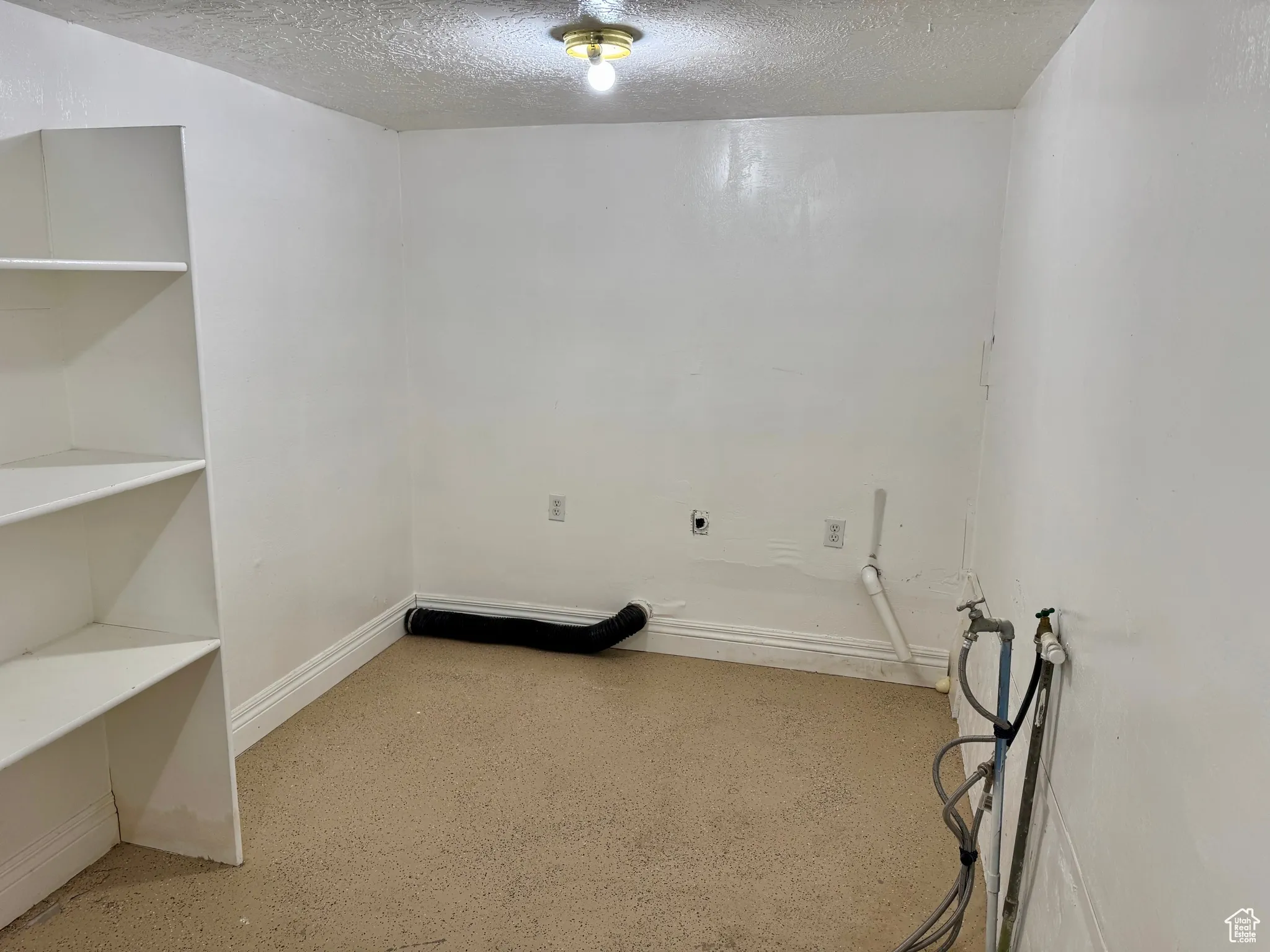 Laundry area with a textured ceiling and hookup for an electric dryer