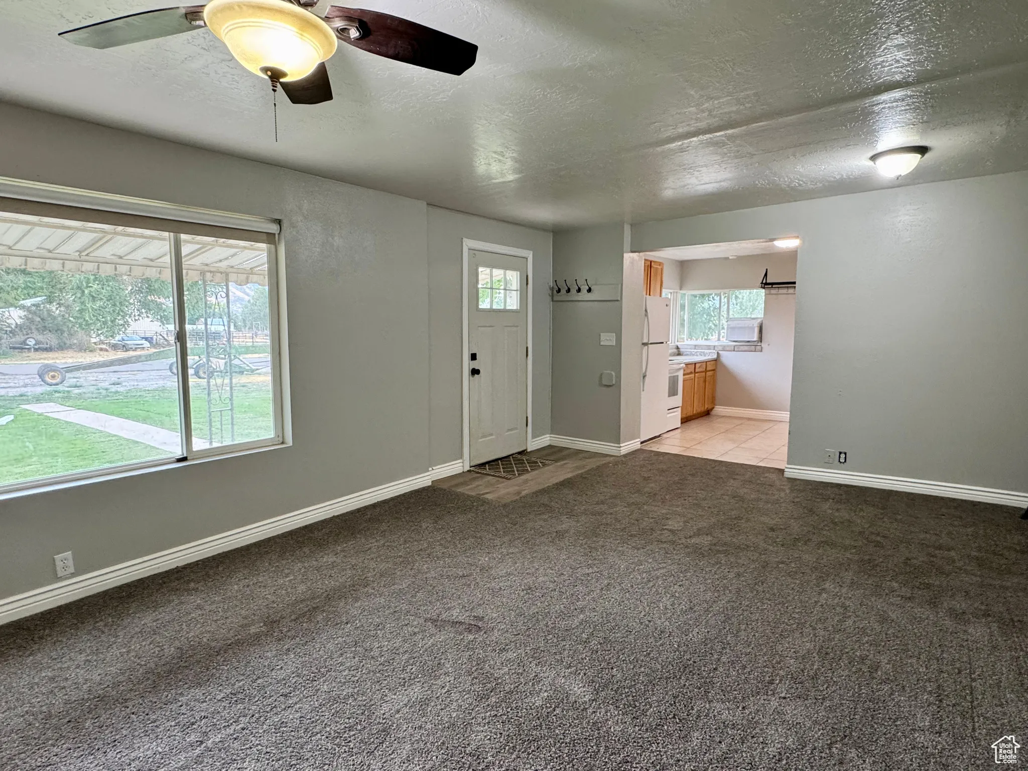 Entryway featuring a textured ceiling and light colored carpet