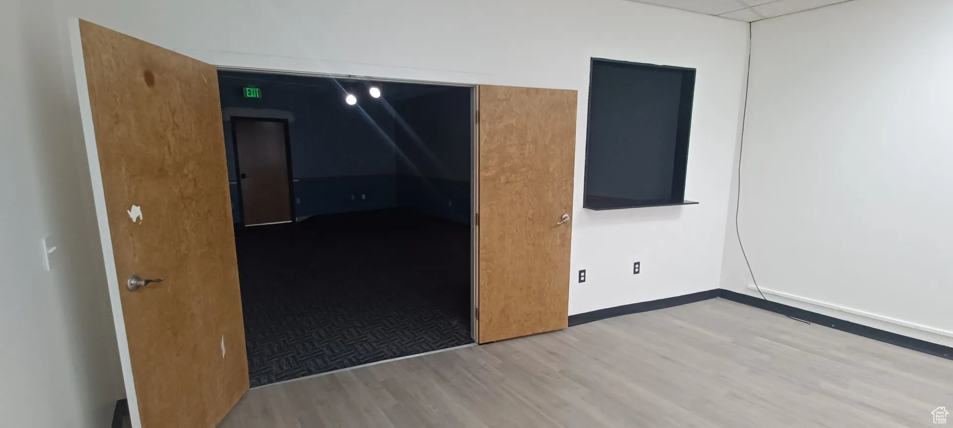 Unfurnished room featuring wood finished floors and a drop ceiling