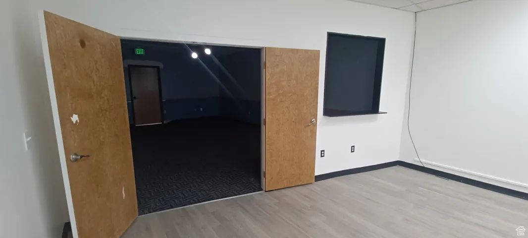 Unfurnished room featuring wood finished floors and a drop ceiling