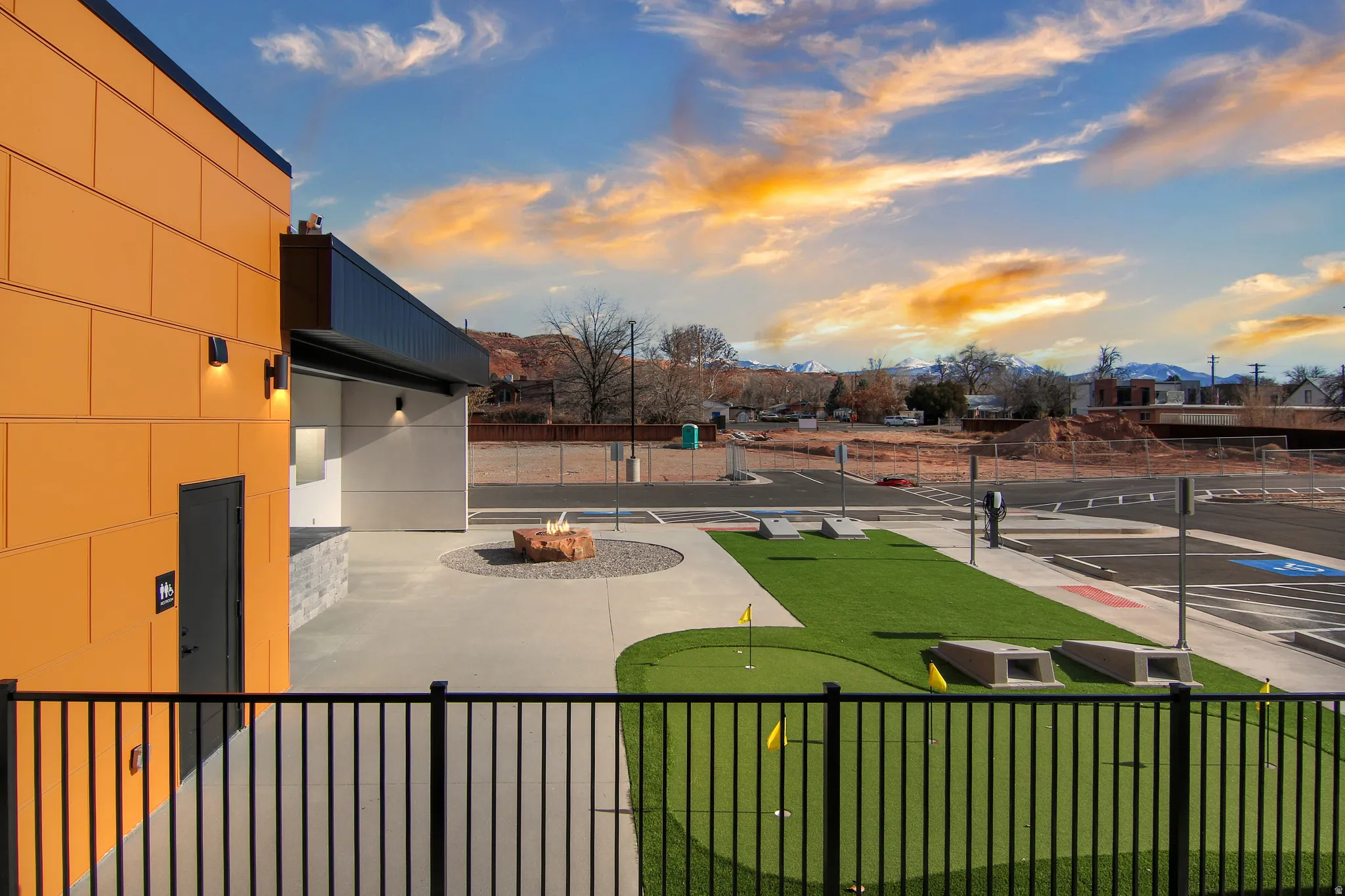 View of yard featuring a putting area, an outdoor fire pit, and a balcony