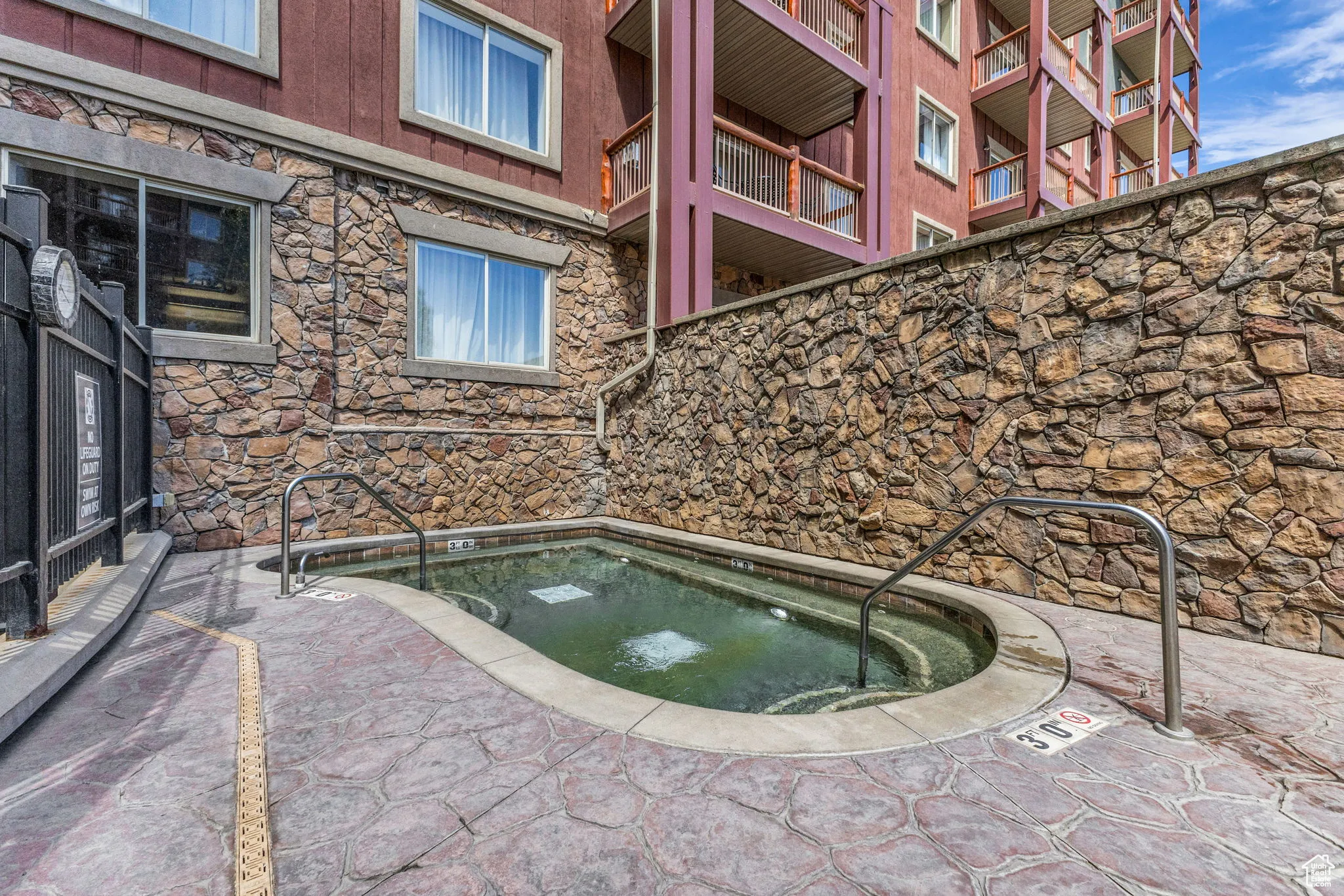 View of swimming pool featuring a hot tub and a patio