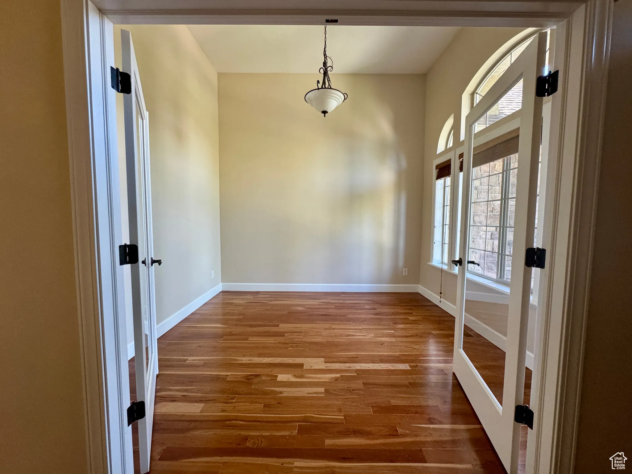 Unfurnished dining area featuring french doors and wood finished floors