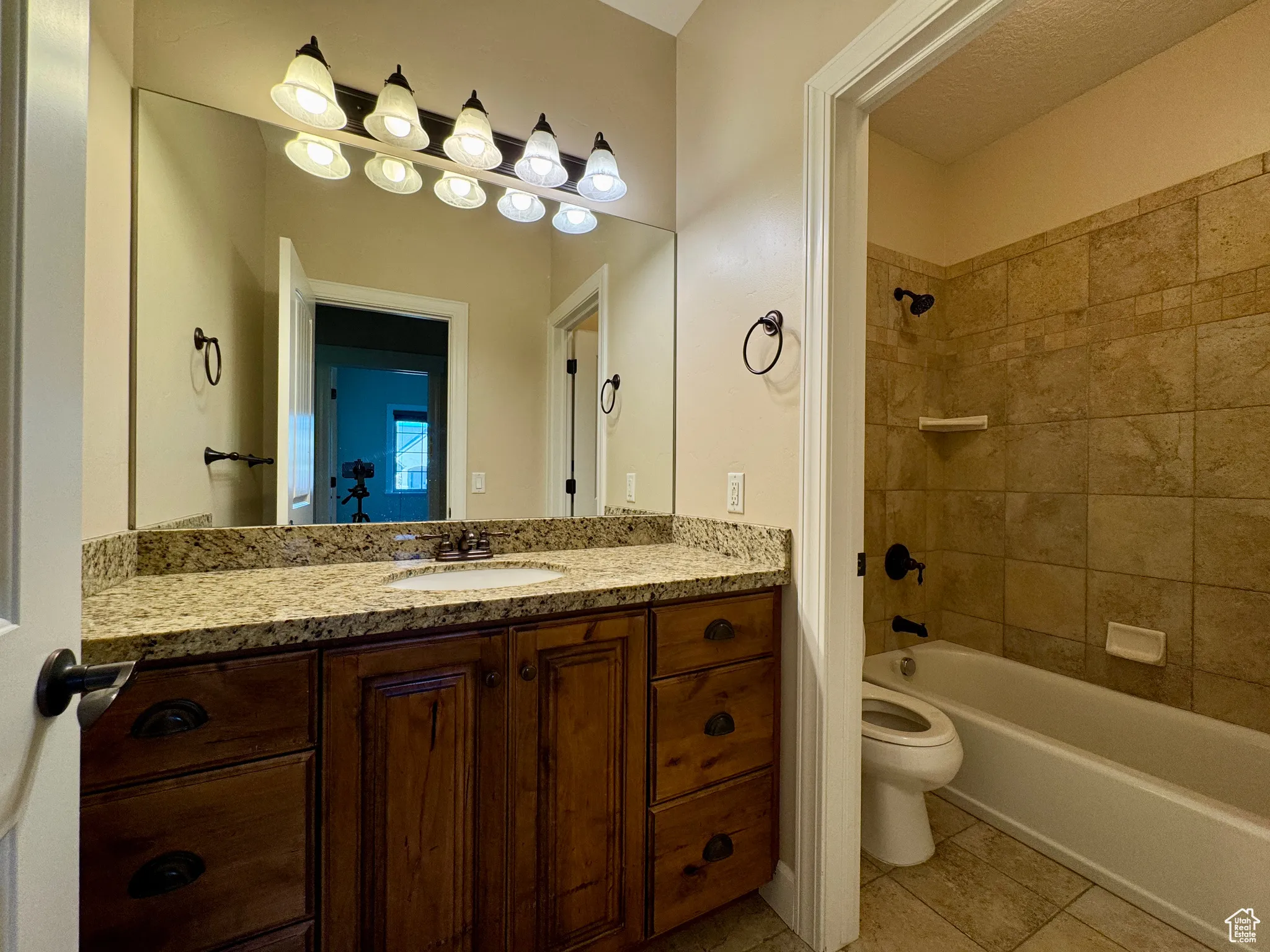 Bathroom featuring shower / tub combination, vanity, and light tile patterned floors