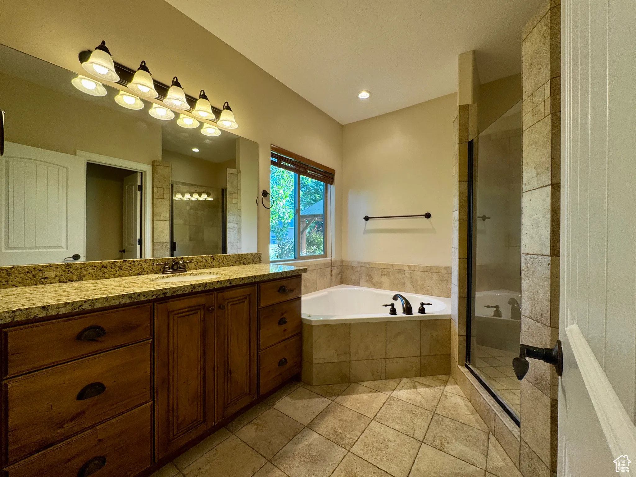 Bathroom with a stall shower, vanity, a bath, light tile patterned floors, and recessed lighting