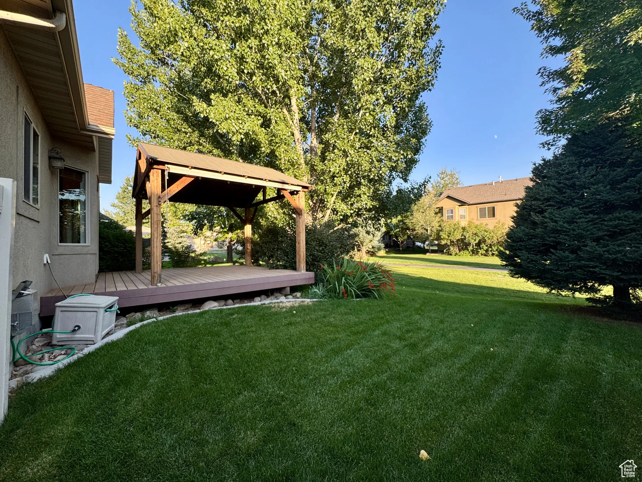 View of grassy yard featuring a deck