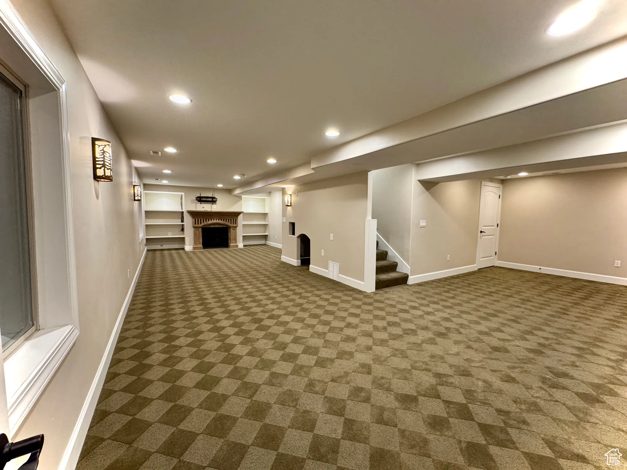 Finished below grade area with recessed lighting, a fireplace, stairway, carpet, and built in features