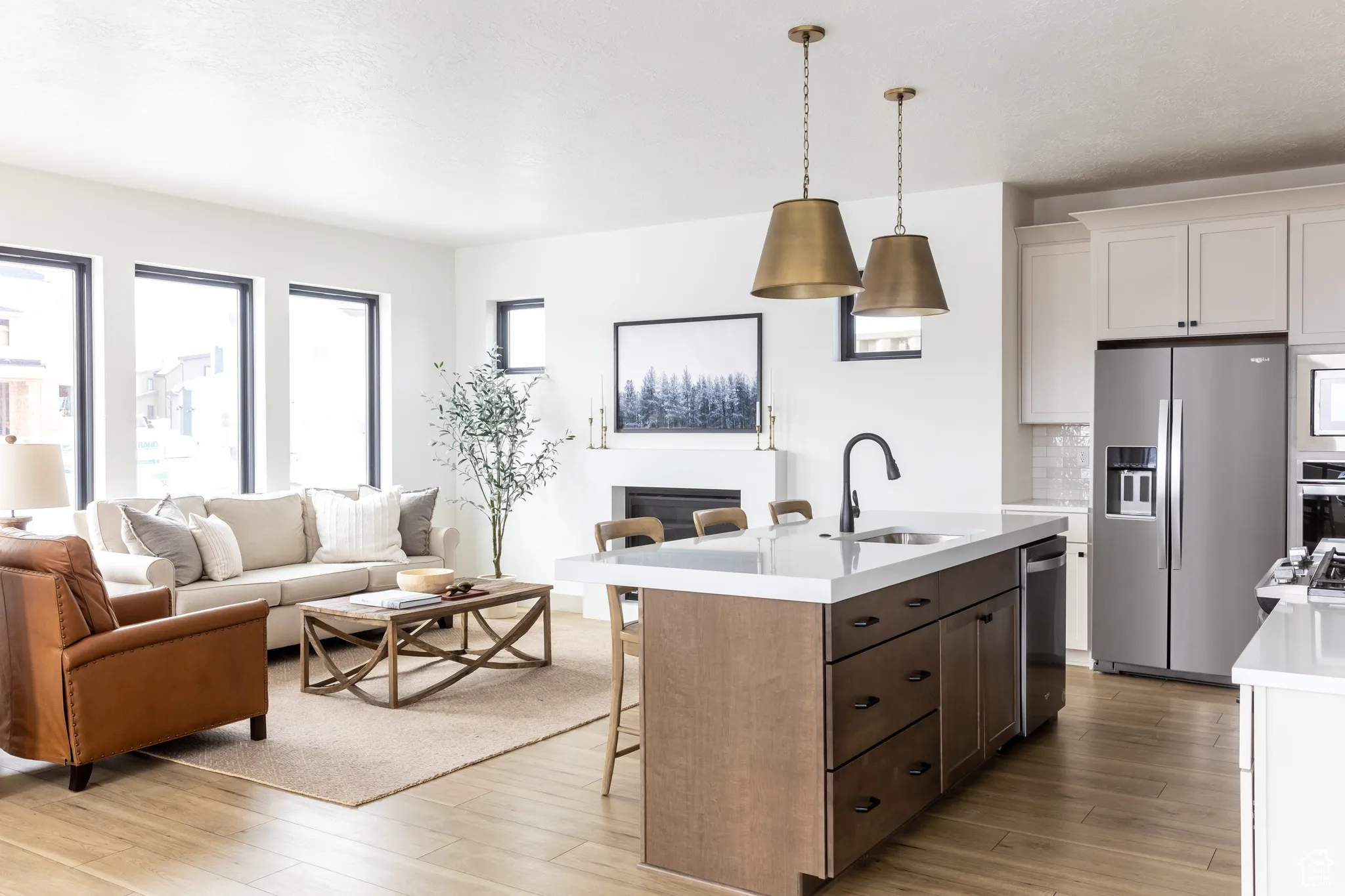 Kitchen with a breakfast bar area, open floor plan, appliances with stainless steel finishes, a kitchen island with sink, and white cabinetry