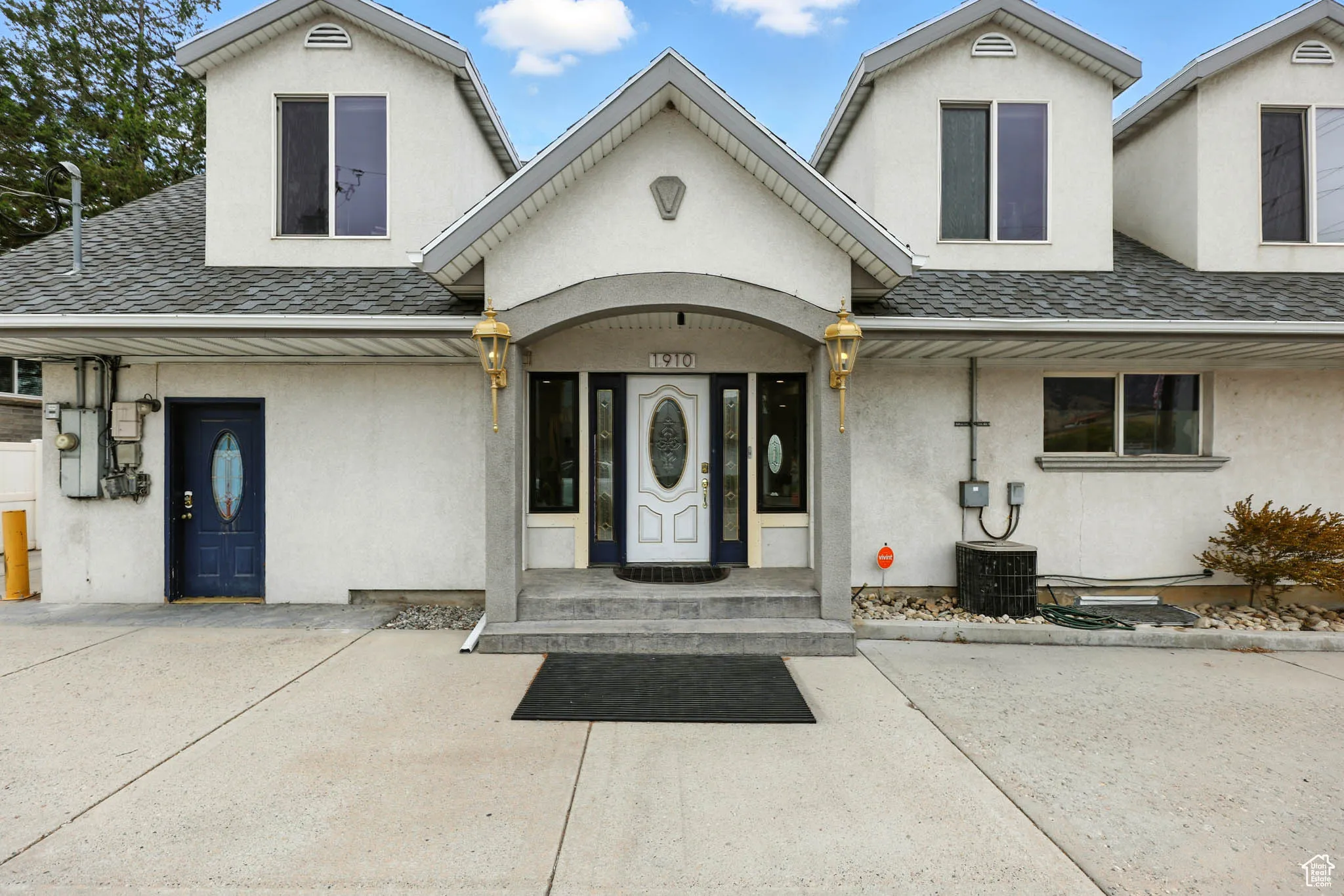Doorway to property featuring stucco siding and roof with shingles