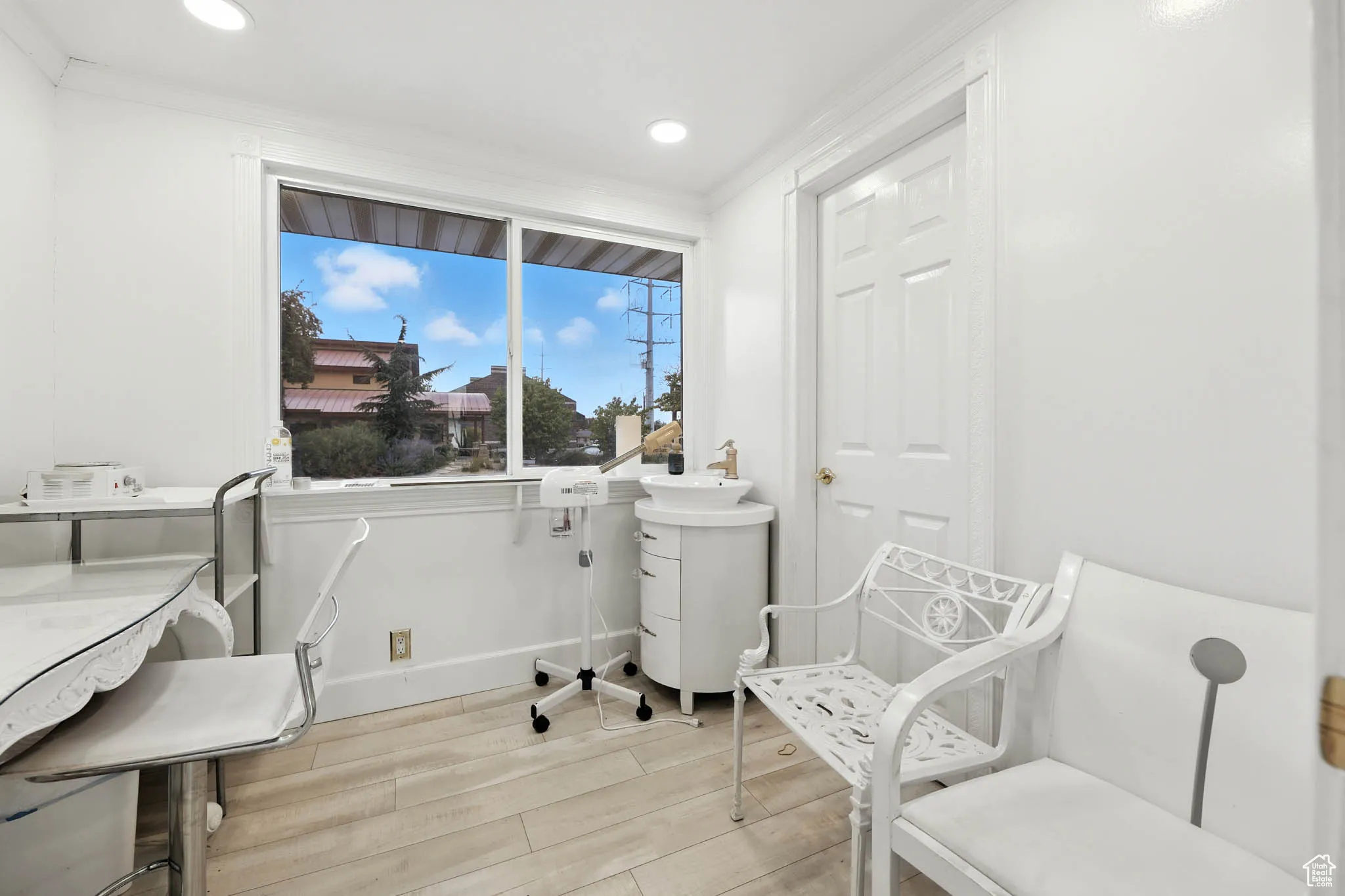 Sitting room with light wood-style floors, ornamental molding, and recessed lighting