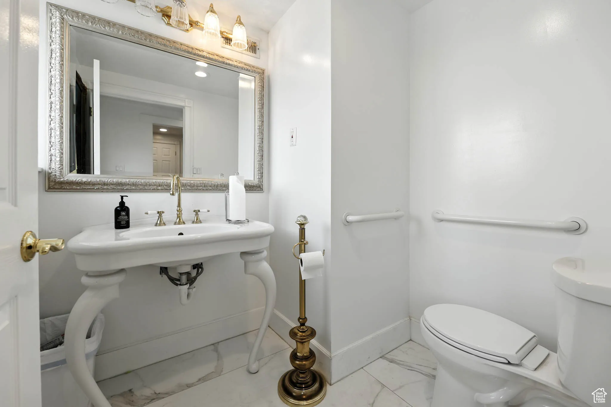 Half bathroom featuring marble look tile flooring and toilet