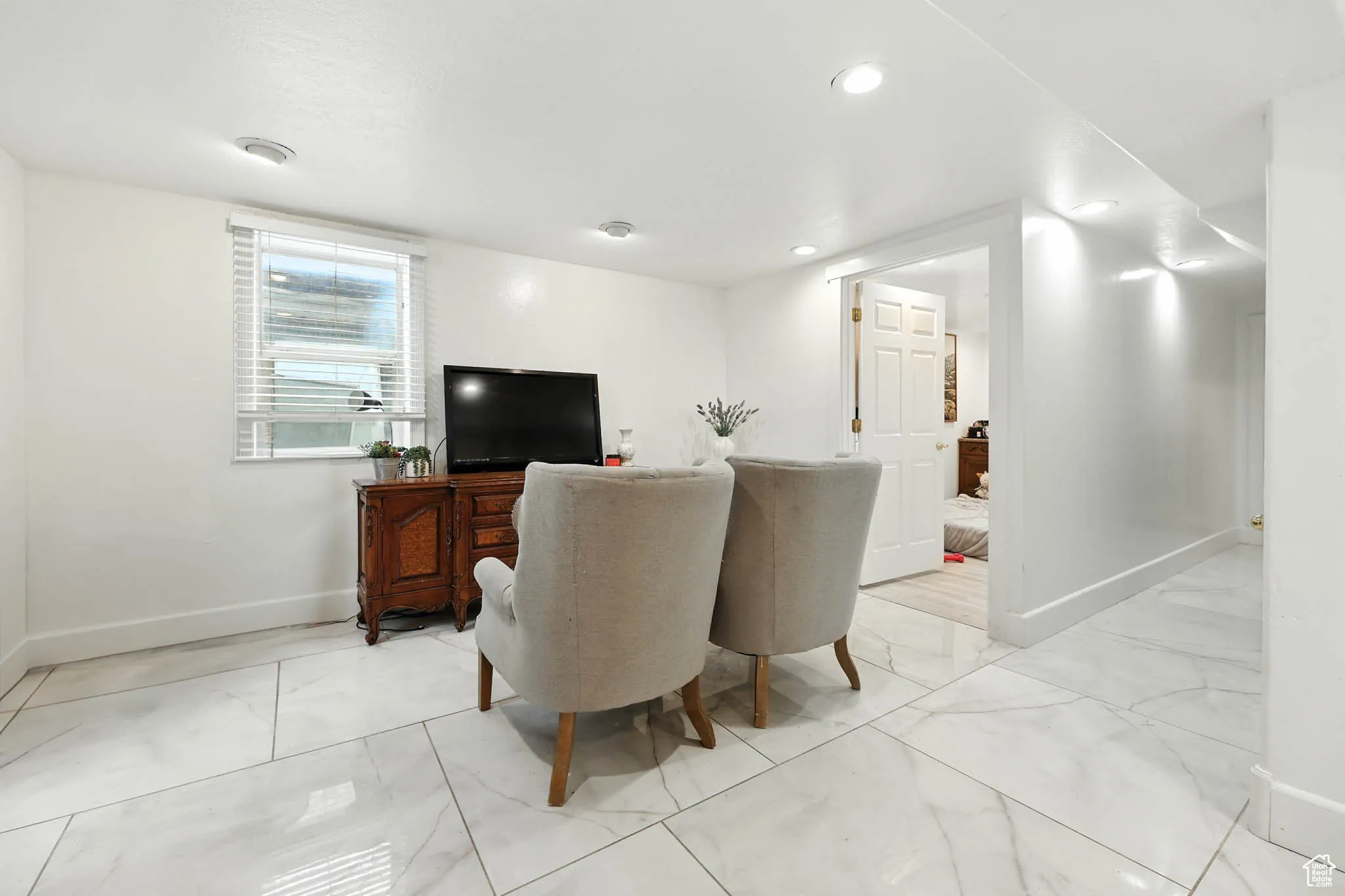 Living room with light marble finish flooring and recessed lighting