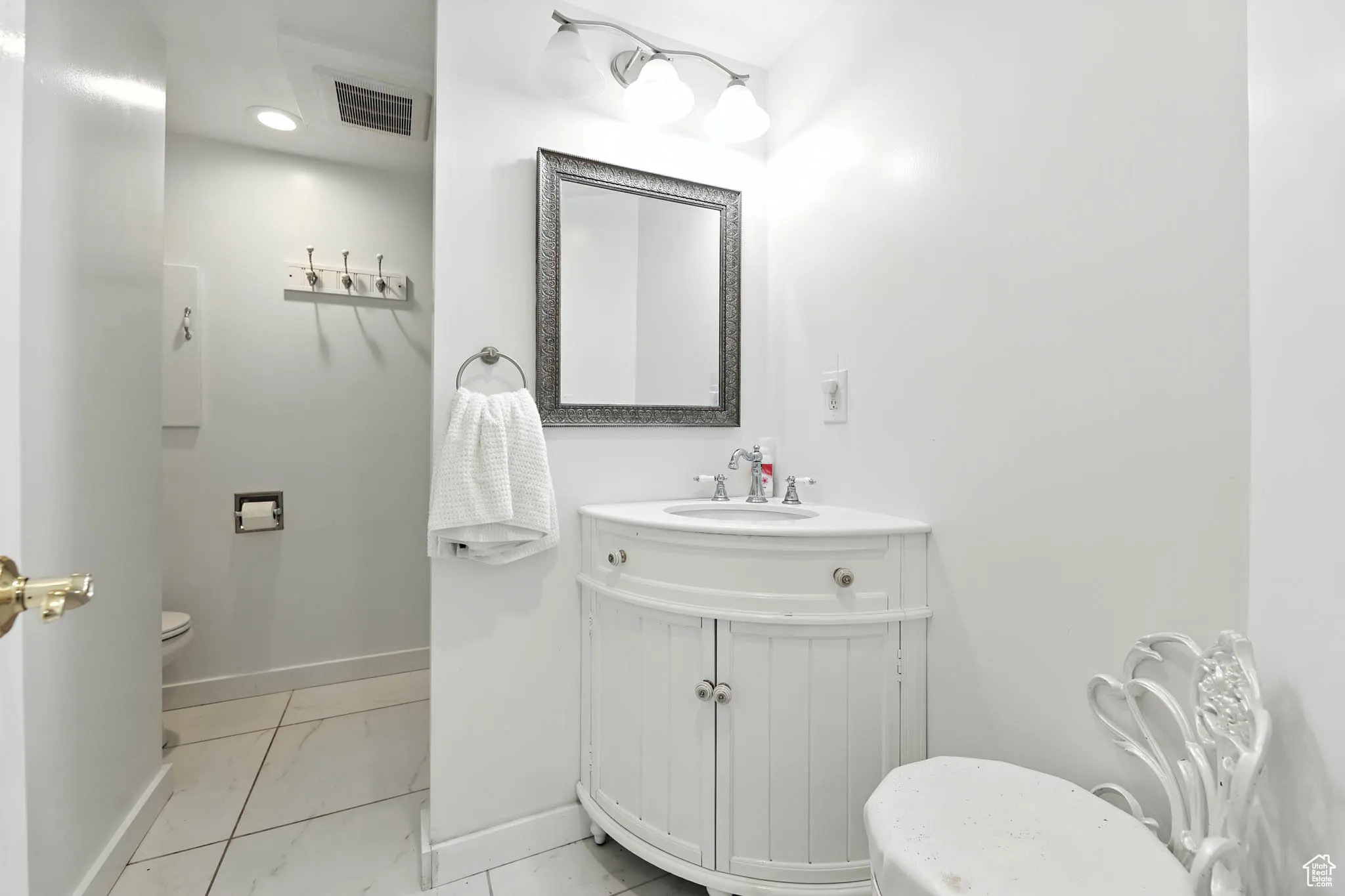 Half bathroom featuring vanity and light marble finish floors
