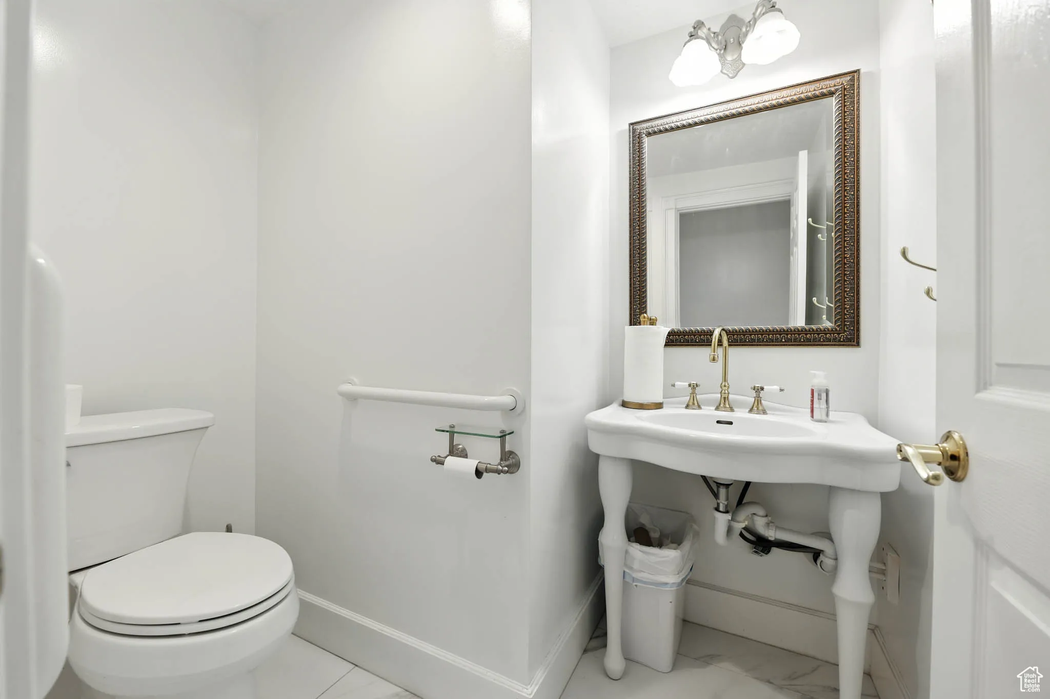 Half bath with toilet and marble finish floors