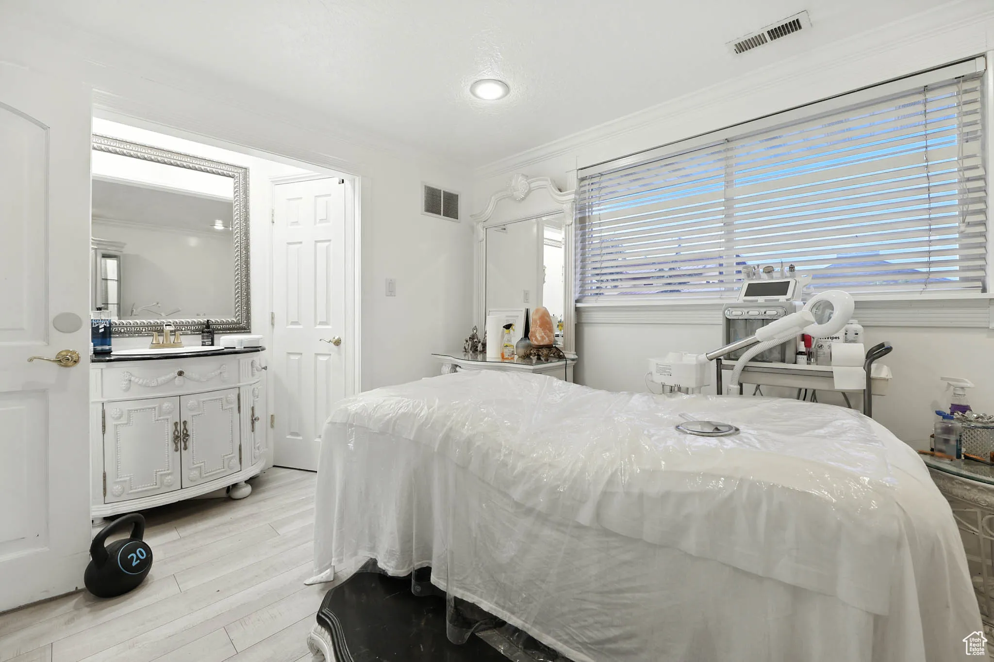 Bedroom with ornamental molding and light wood-type flooring