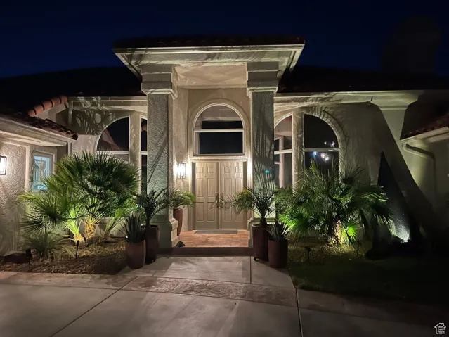 Exterior entry at twilight with stucco siding