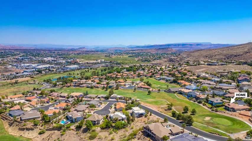 Aerial perspective of suburban area featuring a local golf course and a water and mountain view