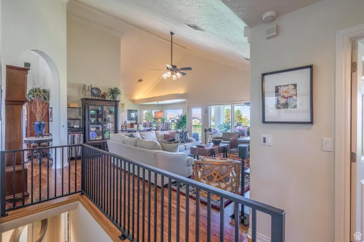 Living room featuring a textured ceiling, high vaulted ceiling, and ceiling fan