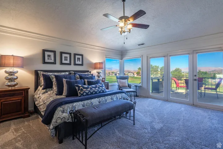 Carpeted bedroom featuring a textured ceiling, access to exterior, ceiling fan, and crown molding