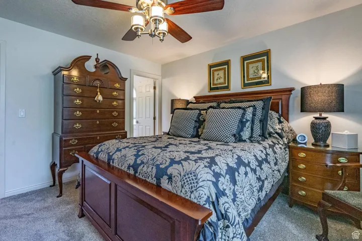 Bedroom featuring carpet flooring, a ceiling fan, and a textured ceiling