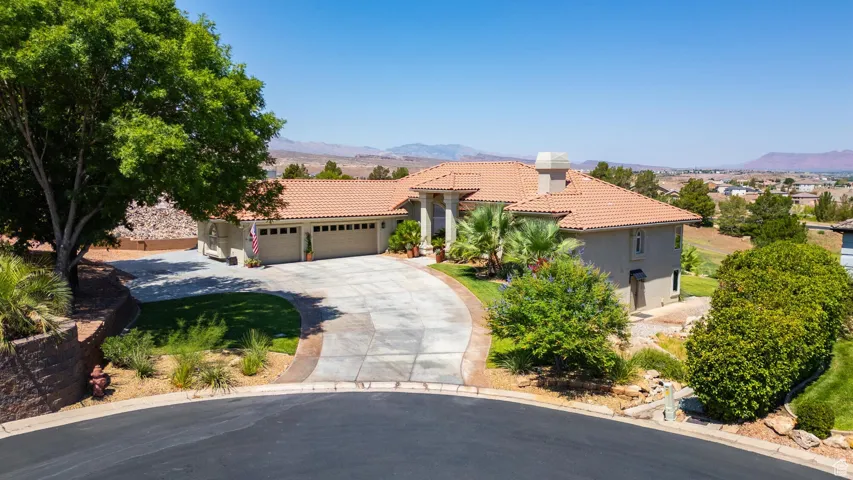 Mediterranean / spanish-style home featuring a garage, a tile roof, driveway, a mountain view, and stucco siding