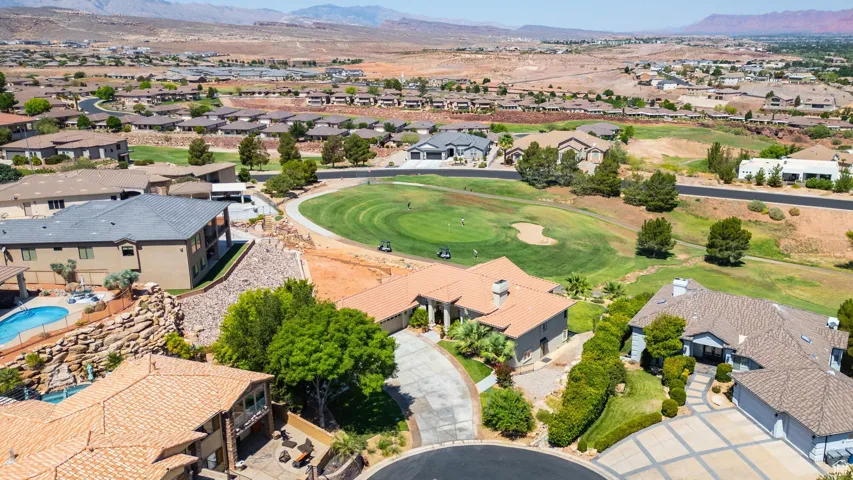 Aerial perspective of suburban area with a mountainous background and a golf course