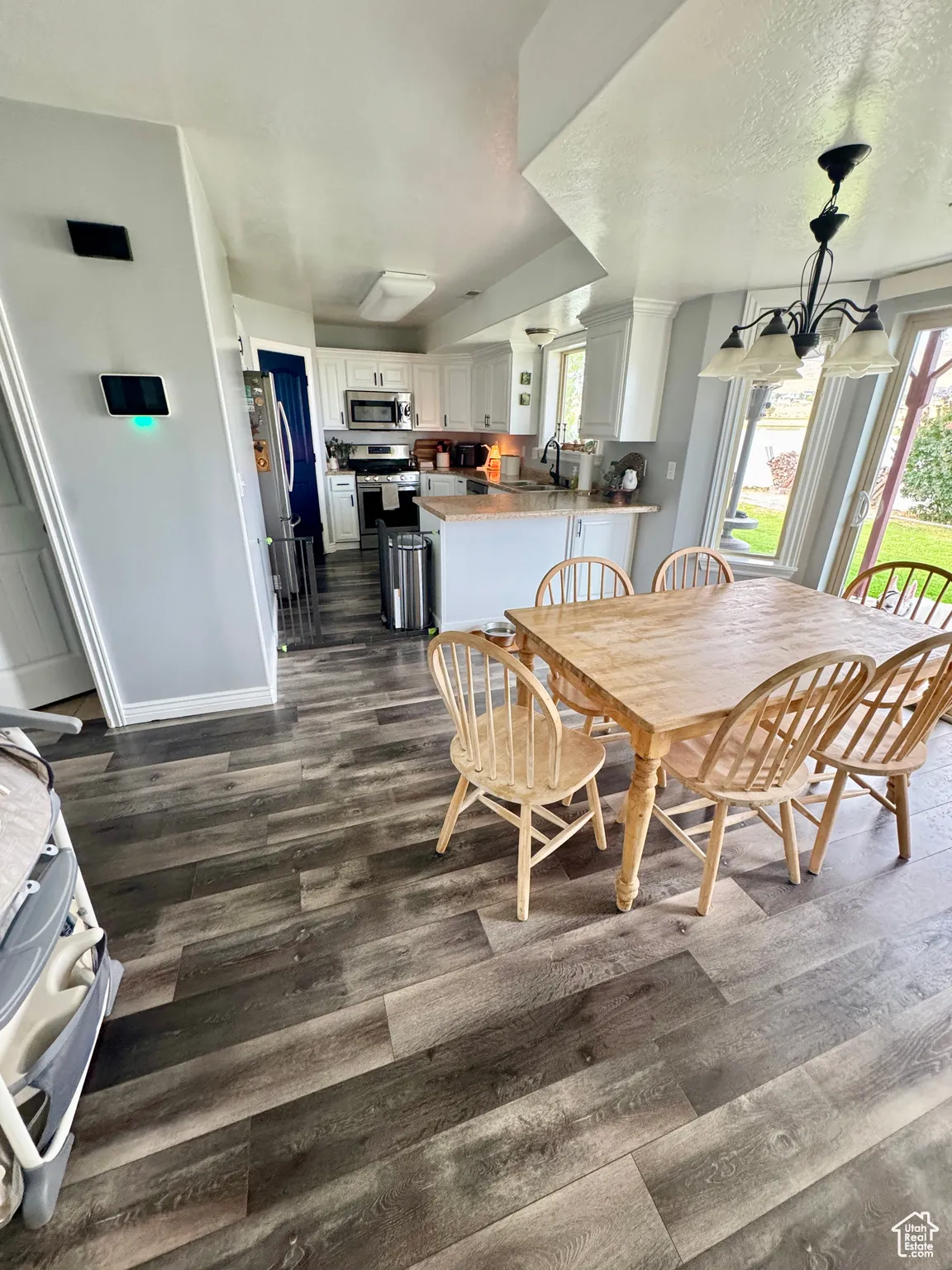 Dining room featuring dark wood-style floors, a textured ceiling, and a chandelier