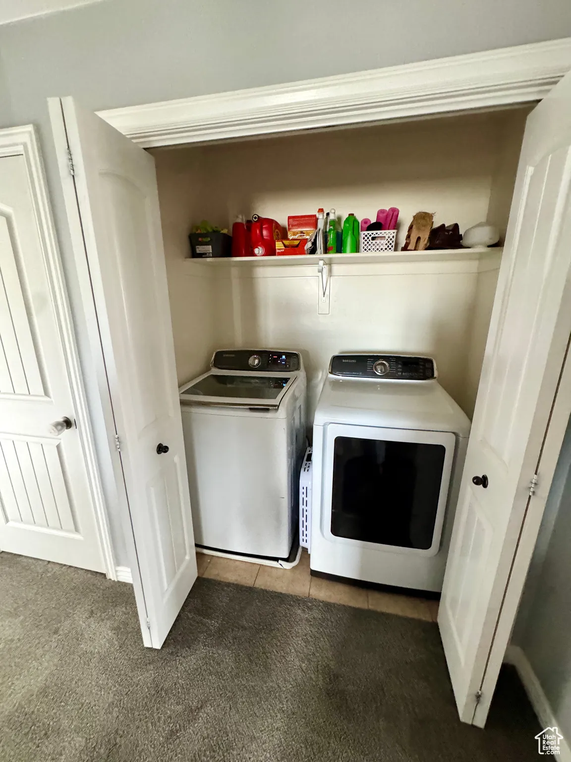 Washroom featuring light carpet, light tile patterned floors, and independent washer and dryer