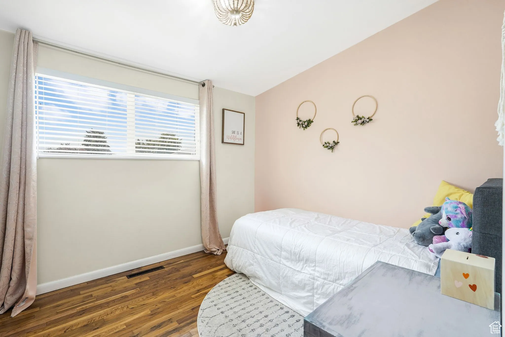 Bedroom with dark wood-style floors and baseboards