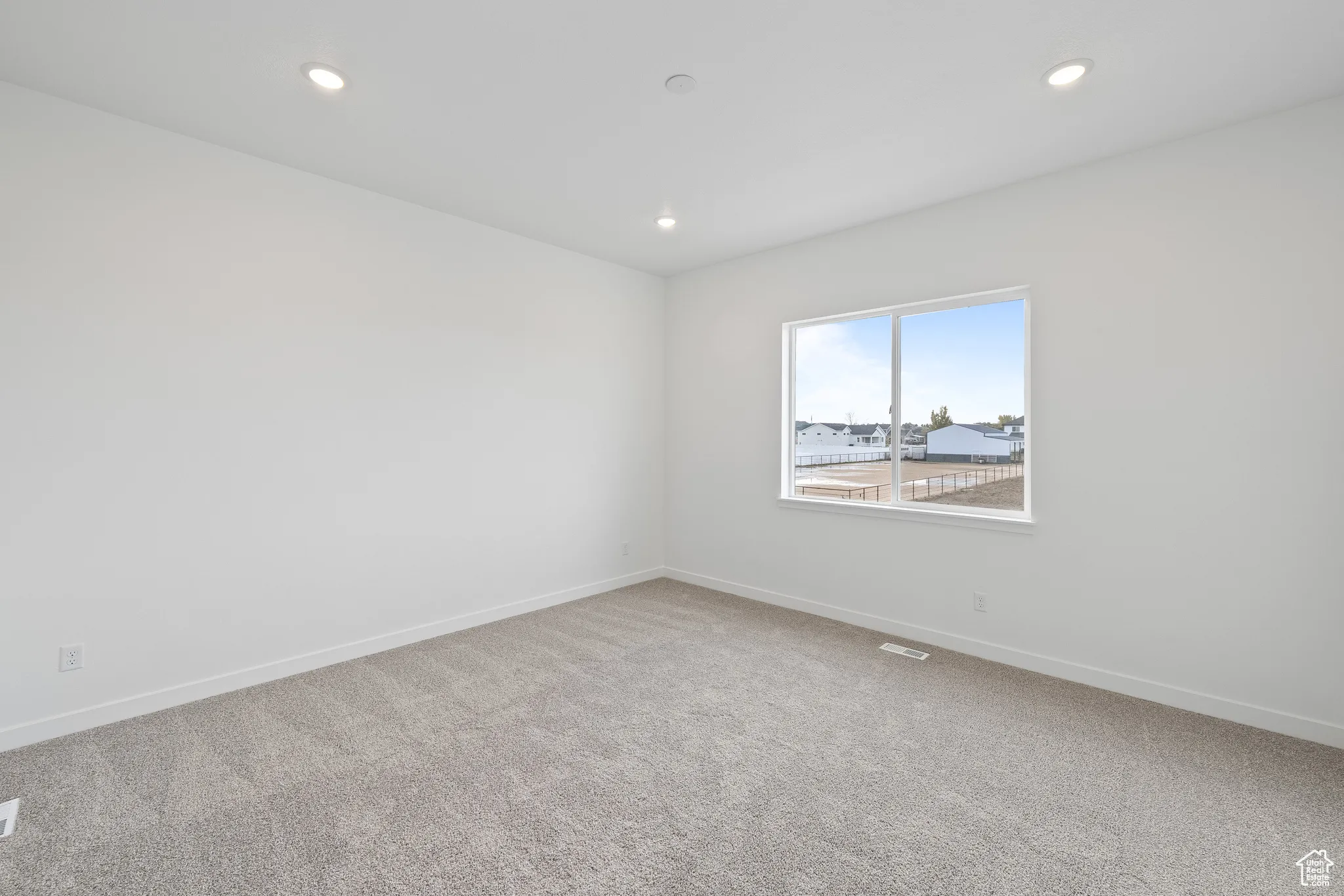 Empty room featuring carpet floors and recessed lighting
