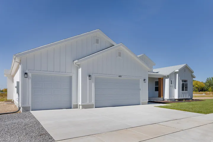 Modern farmhouse featuring an attached garage, board and batten siding, and concrete driveway
