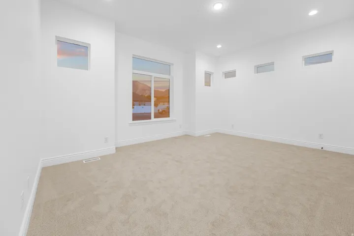 Unfurnished room with light carpet and recessed lighting